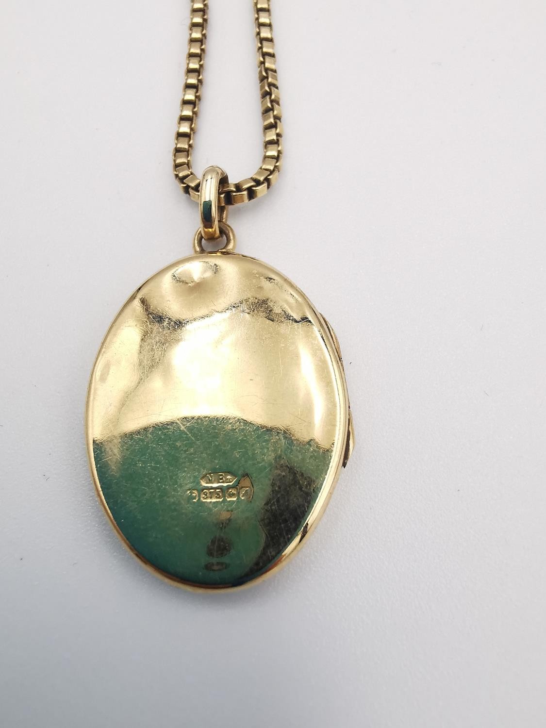 A 9ct yellow box chain and 9ct yellow gold engraved oval locket. The oval locket with a stylised - Image 3 of 6