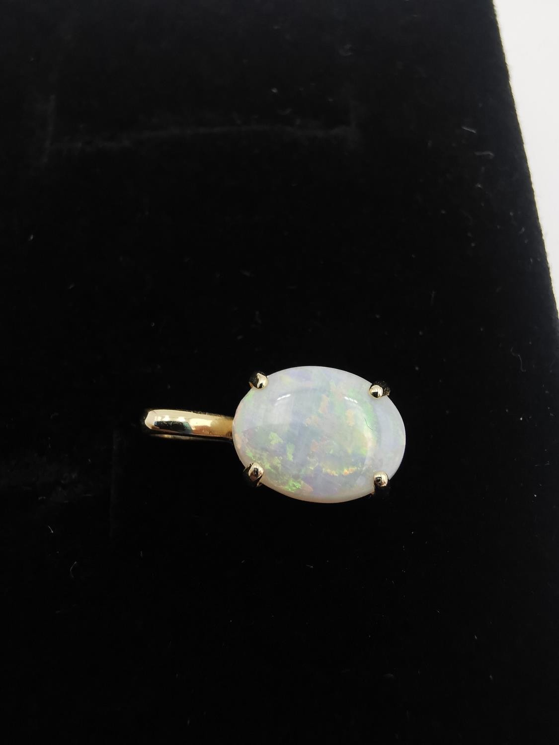 An 18ct yellow gold mounted opal pendant. The pendant set with an oval opal cabochon in an open back - Image 2 of 8