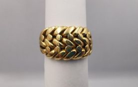 A Victorian 18 carat yellow gold keeper ring with plaited design, tri-strand trumpeting shoulders