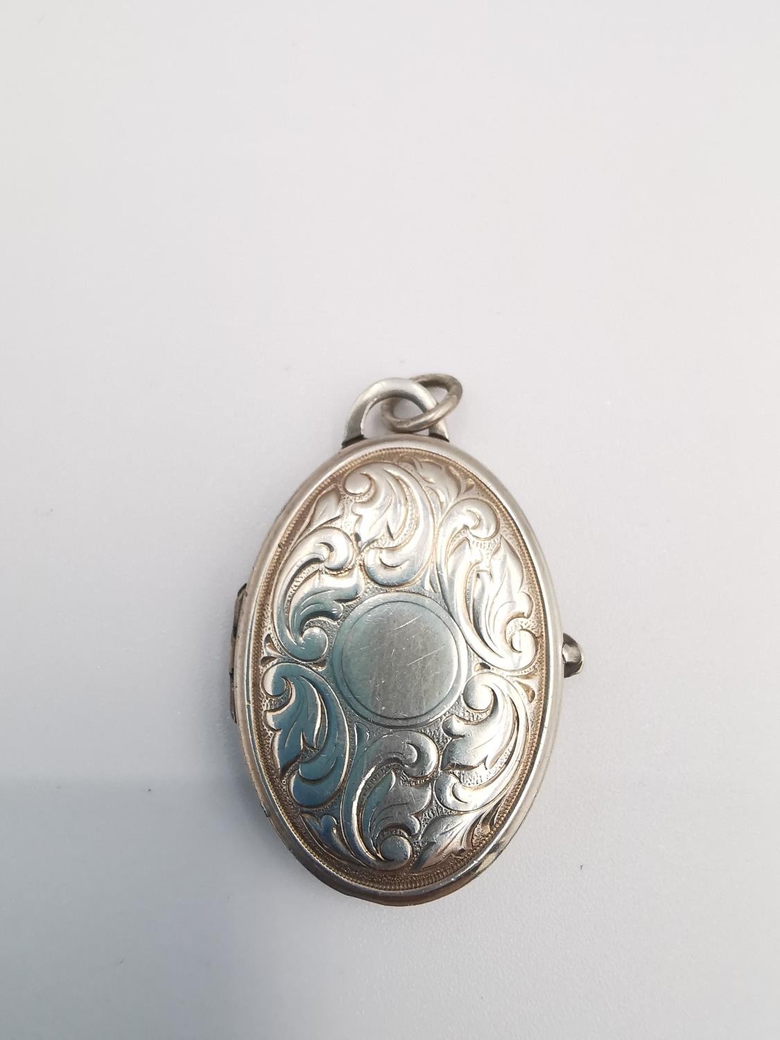 A heavy sterling silver oval locket with stylised scrolling foliate design with cross hatch design - Image 5 of 8