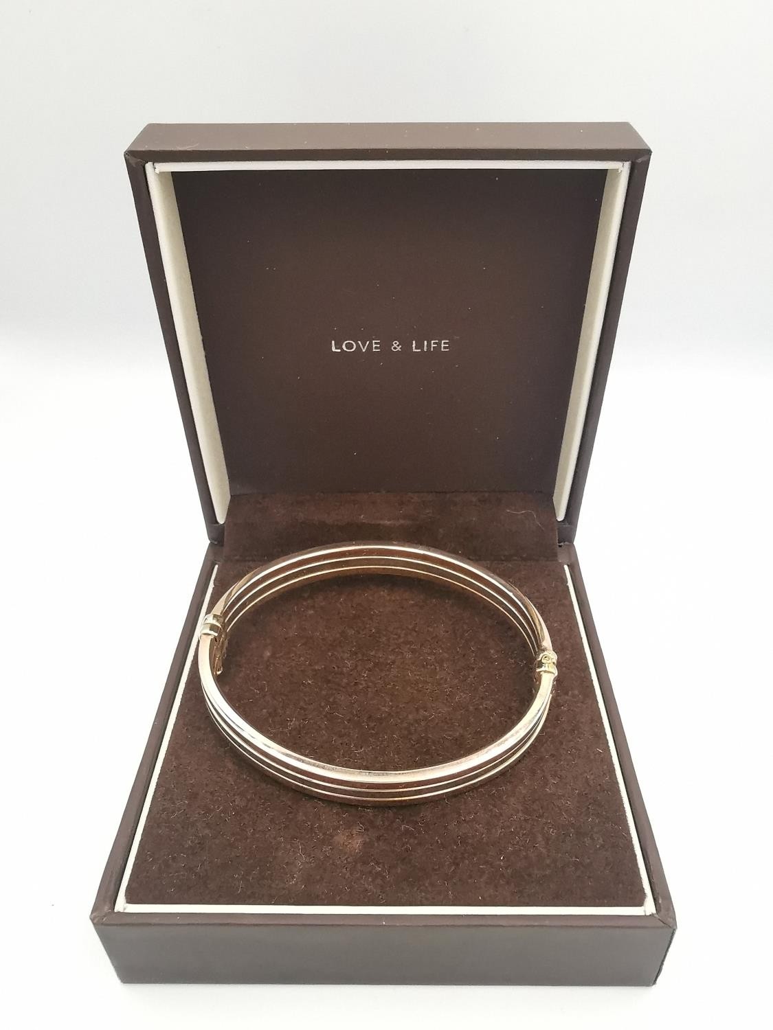 A modern 9ct three colour gold hinged bangle. The bangle comprised of three bands, white, rose and - Image 2 of 5