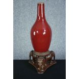 A Chinese flambe glaze bottle vase on a carved raised elephant stand. The stand is made up of