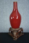 A Chinese flambe glaze bottle vase on a carved raised elephant stand. The stand is made up of