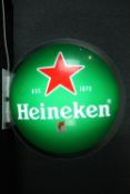 A wall mounted illuminated Heineken sign. Dia. 70 cm.