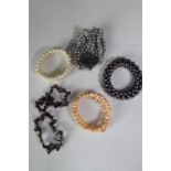 A collection of six cultured pearl elasticated bracelets of various designs, including a grey