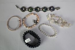 A collection of six cultured pearl bracelets of various designs, including a blue enamel and white