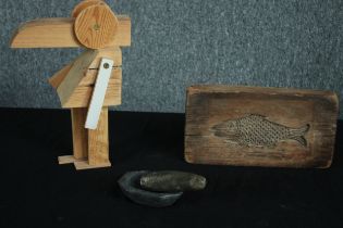 A small fossilized stone pestle and mortar, carved fish butter mould and a limited edition