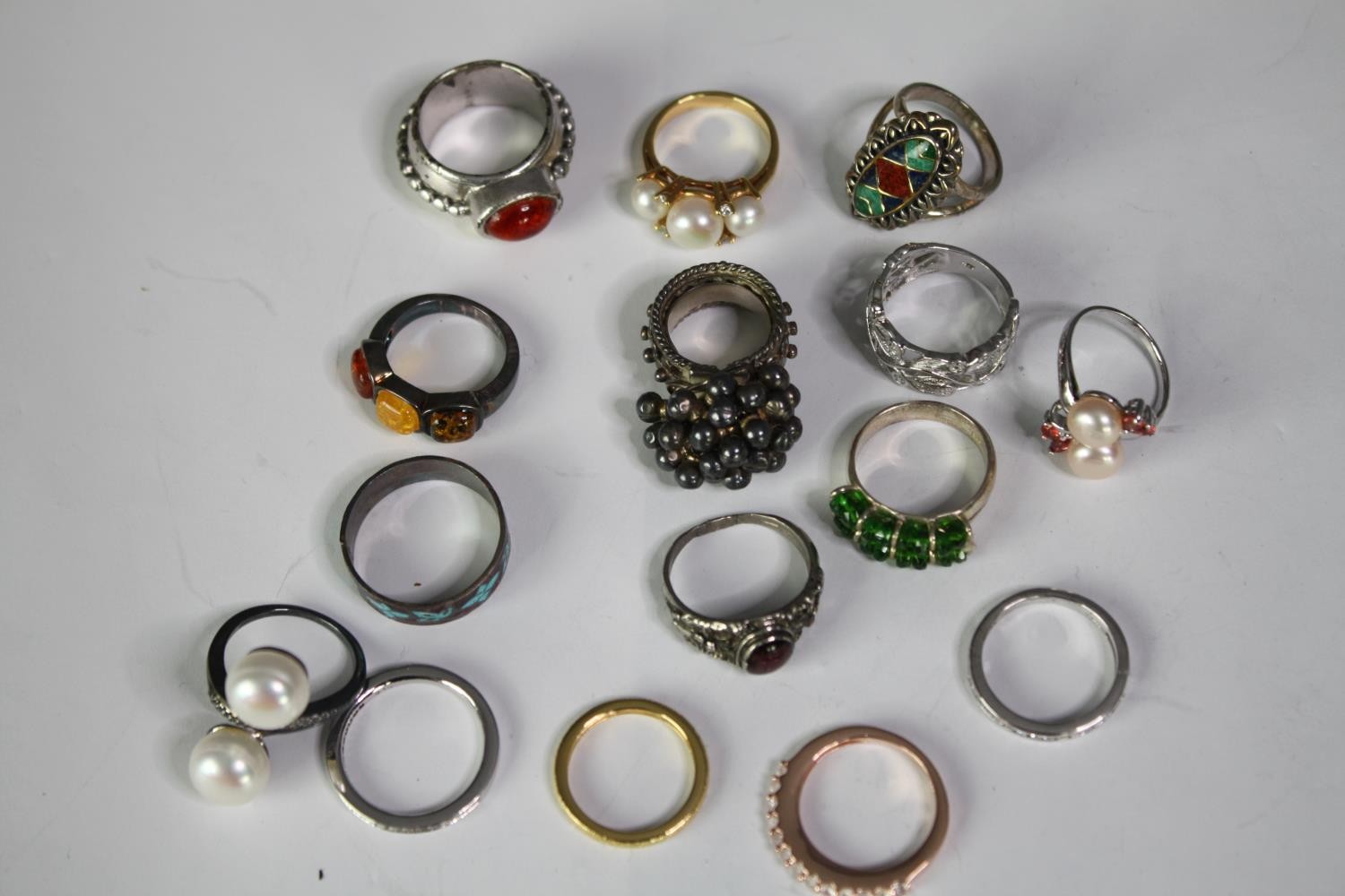 A collection of fifteen silver and silver and gem-set rings of various designs. Set with pearls,