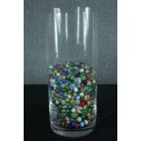 A collection of various sized marbles. In a glass vase. Dia.18 cm.