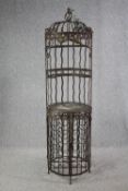 A large vintage wrought iron wine rack with a decorative birdcage attached. H.186 Dia. 50cm.