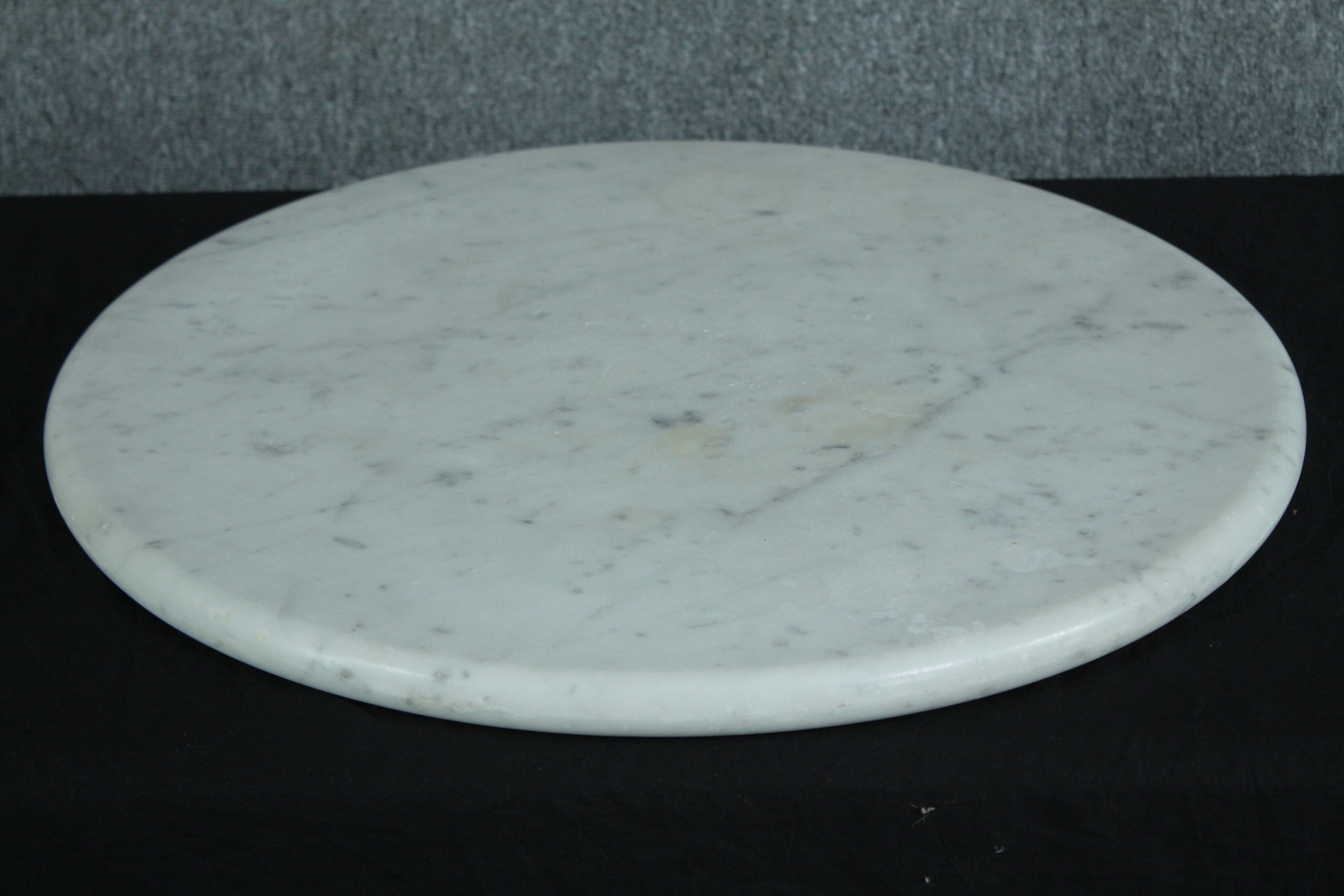 A large round marble cutting board with a diameter of 60 cm.