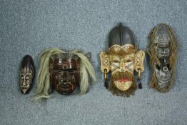 A collection of four carved hardwood Tribal masks. H.53cm. (largest)
