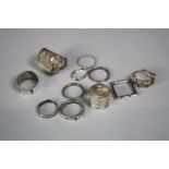 A collection of eleven contemporary silver rings, each with a different design and size. All stamped