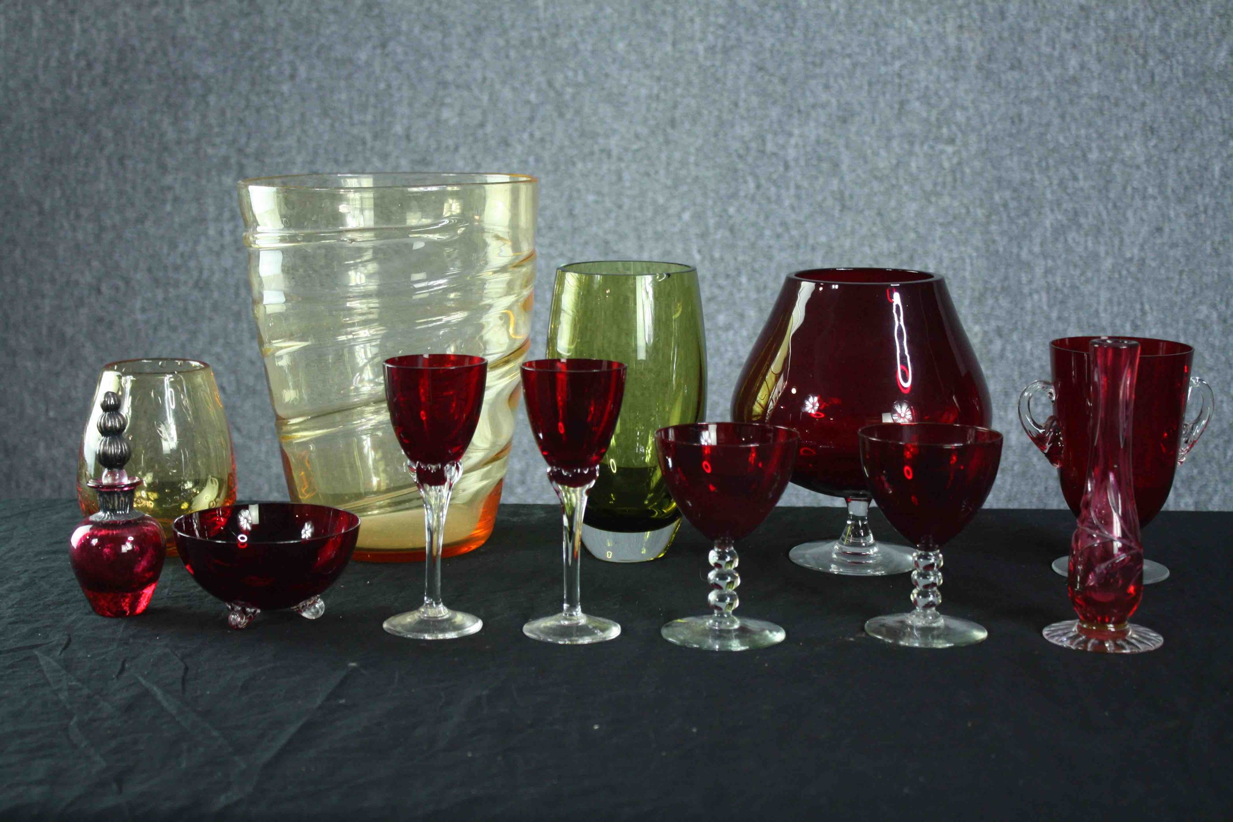 Studio glass. A mixed collection of coloured glass including vases and a pair of ruby glass sherry