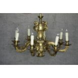 A French brass eight branch chandelier. Mounted with metal cherubs finished in gilt at the base