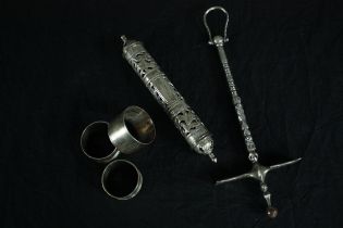 A tribal metal sugar hammer from the Tuareg people along with three silver napkin rings and a