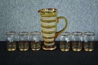 A vintage water jug and six matching glasses. The cups with a matching floral motif. H.27cm. (