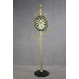 A decorative floor standing clock on a metal stand. H.196 cm.