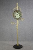 A decorative floor standing clock on a metal stand. H.196 cm.