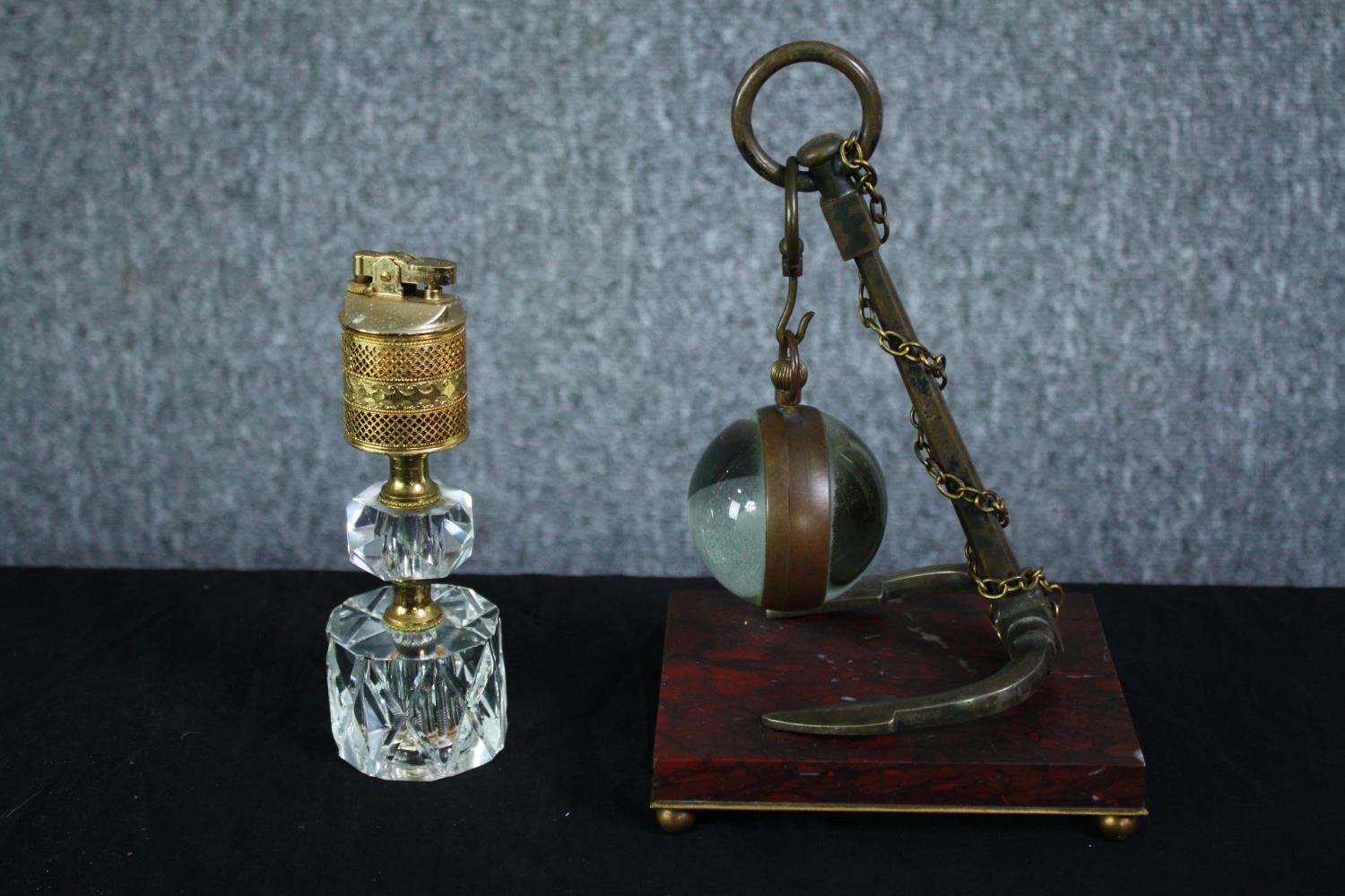 A glass ball suspended by an anchor. The glass ball would once have held a clock. Not present. Also,