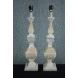 A pair of tall carved, limed and distressed painted table lamp bases. H.74cm. (each)