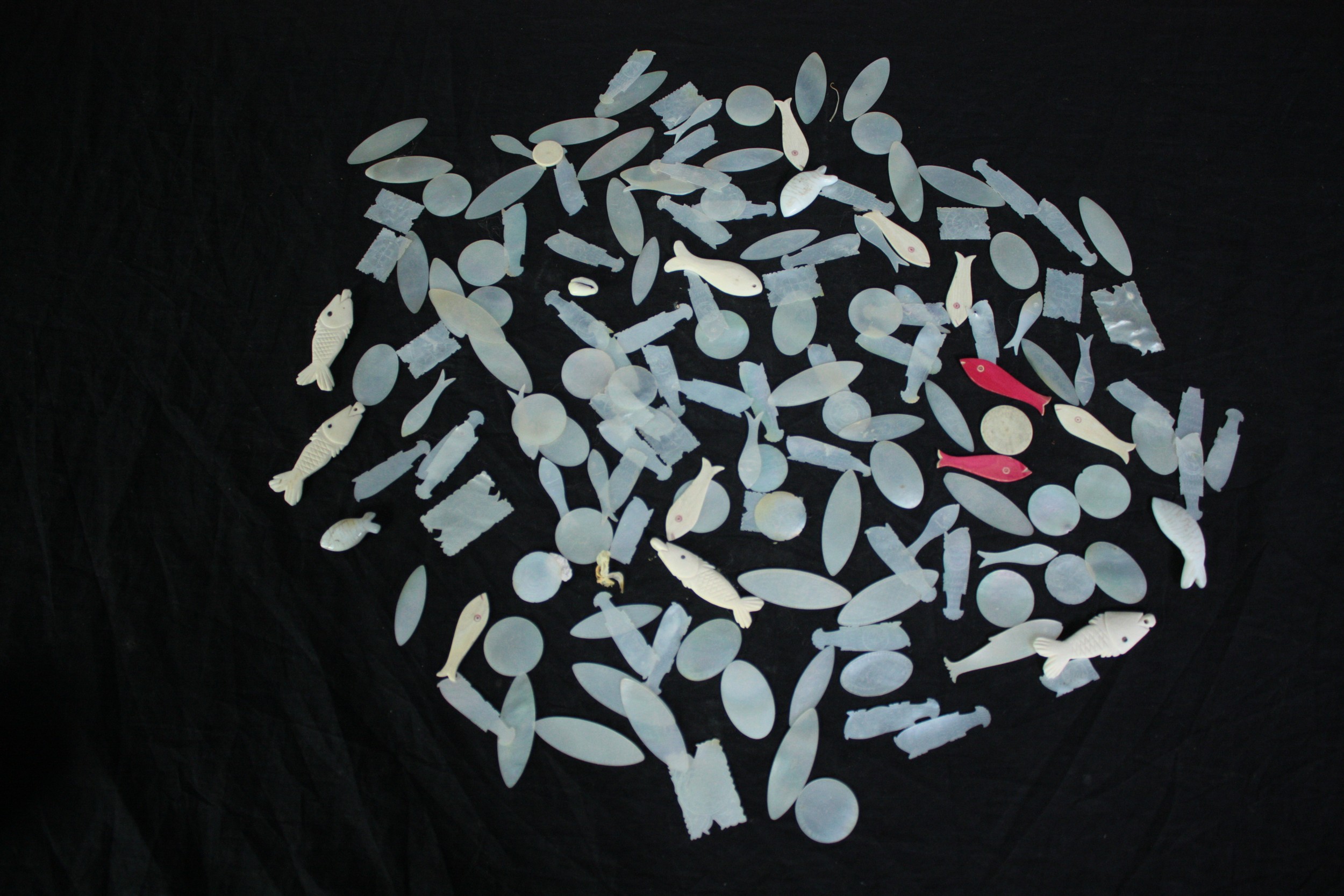 A large collection of mother of pearl carved Chinese gaming chips.