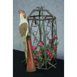 A decorative birdcage with a carved parrot perched outside. The cage containing flowers. H.60 cm.