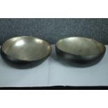 A pair of metal display bowls. Slightly off kilter. Polished metal with a black painted base. Dia.