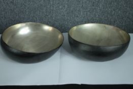 A pair of metal display bowls. Slightly off kilter. Polished metal with a black painted base. Dia.