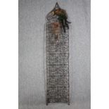 A large lattice iron screen. With feathers and a copper heart shaped decoration. Twentieth