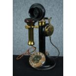 An old candlestick phone made of brass and bakelite. H.31 cm.