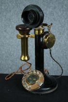 An old candlestick phone made of brass and bakelite. H.31 cm.