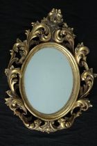 A Rococo style wall mirror in moulded gilt frame. H.65 W.50cm.