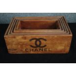 A graduating set of wooden crates marked with a designer logo. H.14 W.35 D.22cm. (largest)