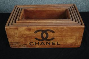 A graduating set of wooden crates marked with a designer logo. H.14 W.35 D.22cm. (largest)