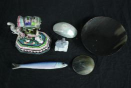 A mixed collection of ceramic ornaments including a fish, elephant, a disk and bowls. The elephant