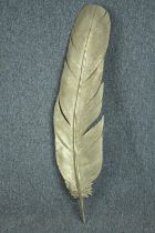 A large decorative carved wood feather painted in gold. L.101cm.