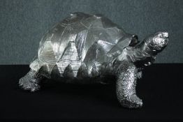 A decorative plaster tortoise painted in silver. H.33 W.60 D.40 cm.