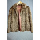 A brown fur short winter coat with pink silk interior. Label to the inside.