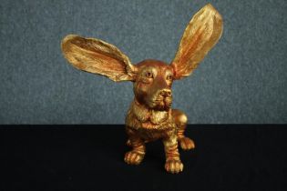 A contemporary dog figure finished in gold. H.34 W. 25 cm.