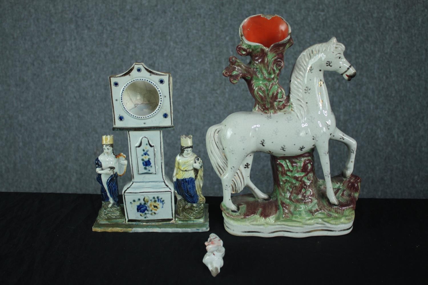 Staffordshire porcelain figures. A candleholder in the shape of a horse, a grandfather clock