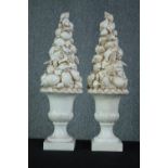 A pair of ceramic sea shell topiary displays in campana urns. H.60cm. (each)