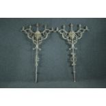 A pair of iron full height wall mounted candelabras. Each with five branches of lights. Painted