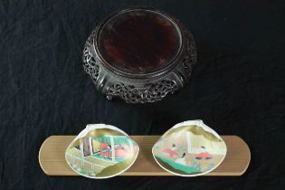 A pair of Japanese hand painted shells and a Chinese pierced hardwood stand. The shells finished