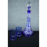 A blue glass decanter and a pair of matching glasses. H.36 cm. (largest)