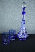 A blue glass decanter and a pair of matching glasses. H.36 cm. (largest)