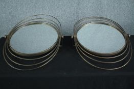 A pair of wall mounted adjustable mirrors in gilt metal frames. H.74 W.54cm. (each).