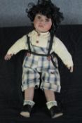 A porcelain china doll with 'A.B.' stamped to the neck. H.50 cm.