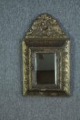 A vintage Dutch repousse brass wall mirror with concealed brush compartment. H.55 W.31 cm.