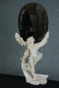 A large figural moulded figure supporting an oval mirror. H.96 W.48cm.